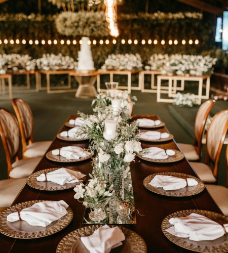 Beautiful wedding reception with elegantly set tables and floral centerpieces in a rustic hall.